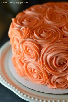 there is a cake with orange frosting roses on it