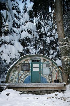 an outdoor toilet in the middle of snow covered trees