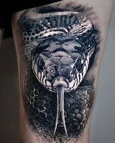 a black and white photo of a snake on the thigh