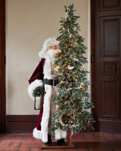 a santa clause standing next to a christmas tree