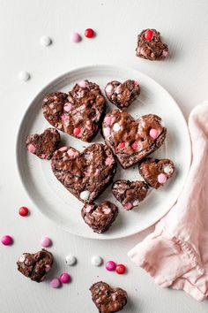 heart shaped brownies on a plate with pink and white candies