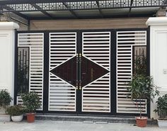 a black and white door with two potted plants