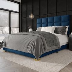 a bedroom with black walls and blue upholstered bed