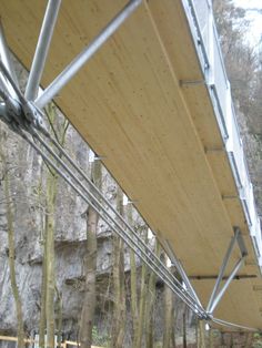 the underside of an awning in front of some trees and rocks with no leaves on them