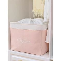 a pink storage bin with personalized name on the side and fringes hanging from it