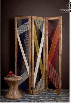 three panel screen with different colors and patterns on the front, one is made out of wood