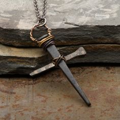 This Men's Cross Necklace Rusty Nails Pendant is handmade from vintage rusty nails. The cross makes a great gift for men or boys. Also great for First Communion or Confirmation gift.The two nails of the cross are welded and hand wound together with copper wire and sealed with a clear satin finish to maintain the rustic vintage look.Size of pendant: Height: 2 inches (5 cm) Width: 1 1/4 inches (3.2 cm)NOTE: Each cross is entirely made by hand, therefore each one is unique and can differ slightly f Diy Cross Pendant, Handmade Medieval Cross Jewelry, Cross Made Of Nails, Deer Horn Jewelry, Metal Crosses, Nail Cross Necklace, Nails Pendant, Rusty Nails, Wire Crosses