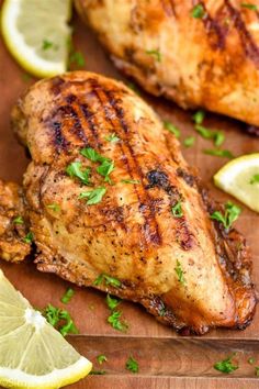 grilled chicken with lemons and parsley on a cutting board