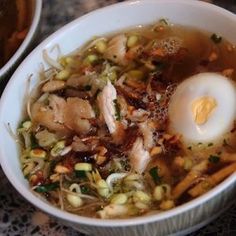 two bowls filled with soup and an egg on top