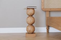 a wooden stool with three balls on it and a comb in the top of one