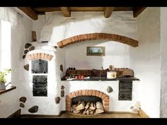 an old fashioned kitchen with brick ovens and wood flooring in the middle of it