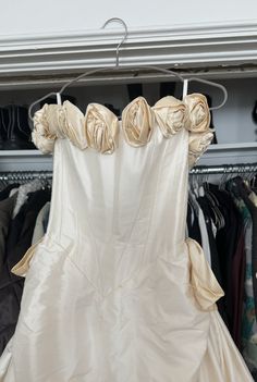 a wedding dress hanging on a rack in a closet