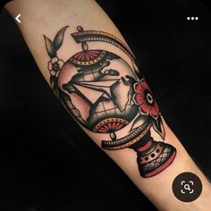 an arm with a tattoo on it that has a clock and flowers in the center