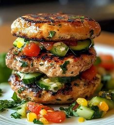 two burgers stacked on top of each other with veggies and sauce in the middle