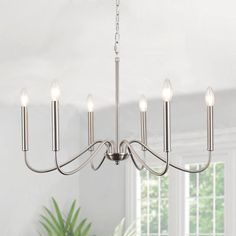 a chandelier hanging from the ceiling in a room with white walls and windows