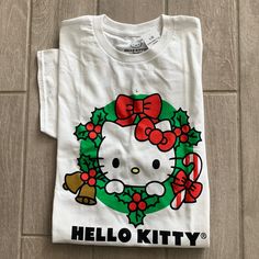 a hello kitty christmas t - shirt is laying on the floor