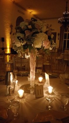 a centerpiece with flowers and candles on a table