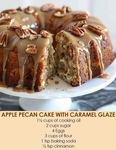 an apple pecan cake with caramel glaze is on a white platter