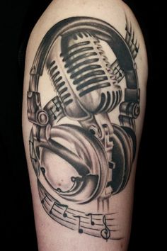 a tattoo with headphones and music notes on the side of his arm, as well as a microphone