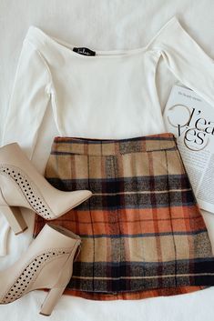 A plaid skirt outfit is an essential look for fall fashion. The colors of autumn come together in a checker pattern throughout the mini skirt. Style with a simple white bodysuit and ankle booties and grab a pumpkin spice latte on the way! #lovelulus Clothes Comfy, Work Outfits Frauen, Rok Outfit, Plaid Skirt Outfit, Rock Outfit, Beige Plaid, 90's Fashion, Cute Fall Outfits, Plaid Mini Skirt