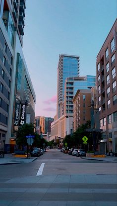 an empty city street with tall buildings in the background