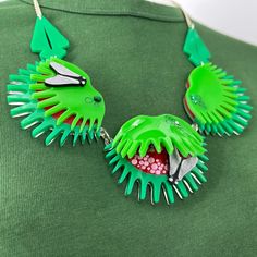 a green necklace with spikes and teeth on it