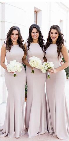 three bridesmaids in long dresses posing for the camera