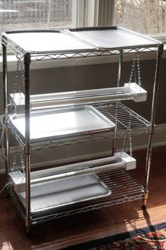 three tiered shelving unit sitting in front of a window