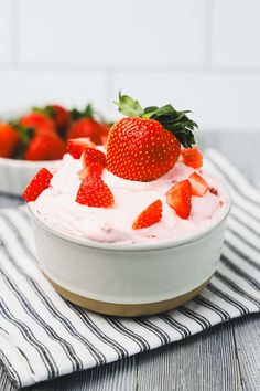 two bowls filled with strawberries on top of a table