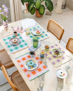 the table is set with colorful plates and cups