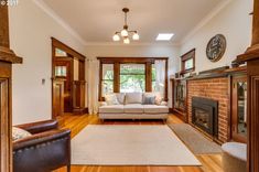 a living room filled with furniture and a fire place in front of a clock on the wall