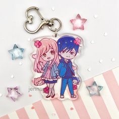 two anime characters are standing next to each other on a star shaped keychain