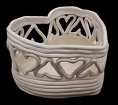 a white wicker basket with hearts on the front and sides, sitting on a black background