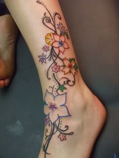 a woman's foot with flowers on it and a butterfly in the middle of her leg