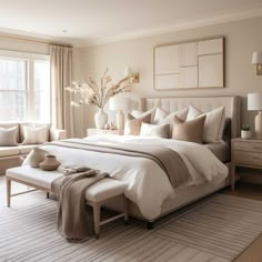 a large white bed sitting in a bedroom next to a window with lots of windows