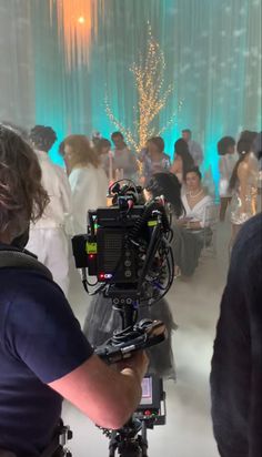 a cameraman filming people at a wedding reception