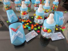 several baby bottles filled with candy and candies on top of a black tablecloth