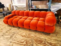 an orange couch sitting on top of a wooden floor