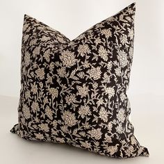 a black and white floral pillow on a white background