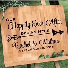 a wooden sign that says happily ever after begins here with an arrow and leaves on it