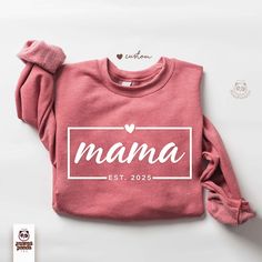 Personalized Mama Sweatshirt / Custom Mama Crewneck Sweatshirt / Customizable Mom Gift / Mama est 2025 Hoodie These beautifully designed shirts will make your day a little extraordinary and meaningful. Made out of good quality cotton and it feels so soft and nice. Please see our size chart and colors (available colors and sizes may vary, please reach us to find out currently available colors and sizes). -> Solid colors such as black, white and pink are 100% cotton. Heather colors are 52% cotton and 48% polyester. -> Use cold water when washing, do not use bleach, do not dry clean, and do not use an iron directly on the design. -> Your Custom T-shirt will be ready to ship 1-3 business day. Holiday times may affect the handling times. Print size will stretch up or down for perfect sight depe Mama Crewneck Sweatshirt, Mama Crewneck, Mama Sweater, Designed Shirts, Boutique Ideas, Mama Sweatshirt, Holiday Time, Be Ready, Mom Gift