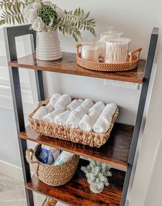 three shelves with towels and baskets on them