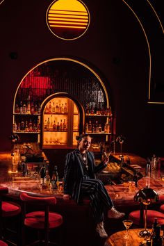 a man sitting at a bar with bottles and glasses