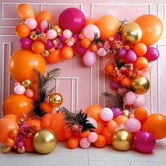 an orange, pink and gold balloon arch