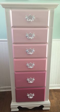 a pink and white dresser sitting on top of a hard wood floor