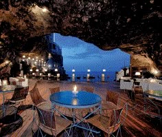 an outdoor dining area with tables, chairs and candles lit up in the night sky