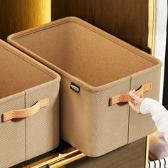 two brown storage bins sitting on top of a dresser