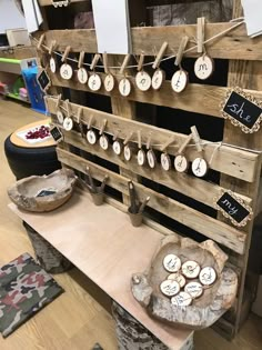 a wooden table topped with lots of different types of clocks on clothes pins hanging from strings