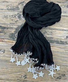 "This celestial scarf is already delightful because of its lightweight weave and carefree design, but wait until you look closer! The large and small stars, the moon shapes, and the shiny beads at the tips of the scarf create an attractive style with unexpected details. This fringed boho wrap is made of black wrinkled cotton, shiny silver  celestial crochet flowers. This shining beaded scarf can be the perfect accessory to complement your elegance. The feminine long wrap scarf has been made espe Celestial Crochet, Boho Celestial, Small Stars, Beaded Scarf, Boho Shawl, Boho Scarfs, Crochet Stars, Crochet Ornaments, Black Wrap