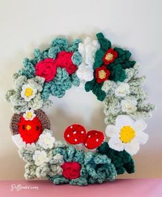 a crocheted wreath with flowers and birds on it